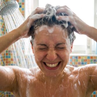 ragazza che si fa lo shampoo sotto la doccia